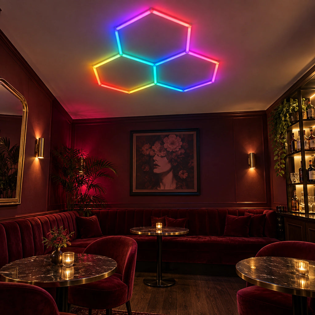 Mise en situation illustrative du kit Plafonnier LED Hexagonal RGB Nid d'Abeille 3 Modules Hexeli™ 1,68 m x 1,66 m – RGB connecté, ambiance RGB lounge. Création commerciale, pas une photo de client réel.